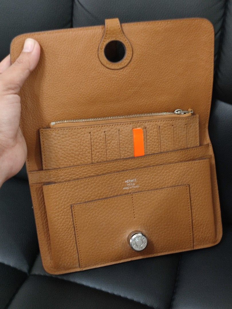Hermes Leather Wallet (Category: Luxury Bags & Wallets) located in Basud. Submitted by ClaireLavin (Listing ID 1422471423, Image 2). Description: - Hermes wallet - Tan leather exterior - Removable card holder with orange stripe - Multiple compartments for cards and cash - Silver-tone hardware with Hermes logo.