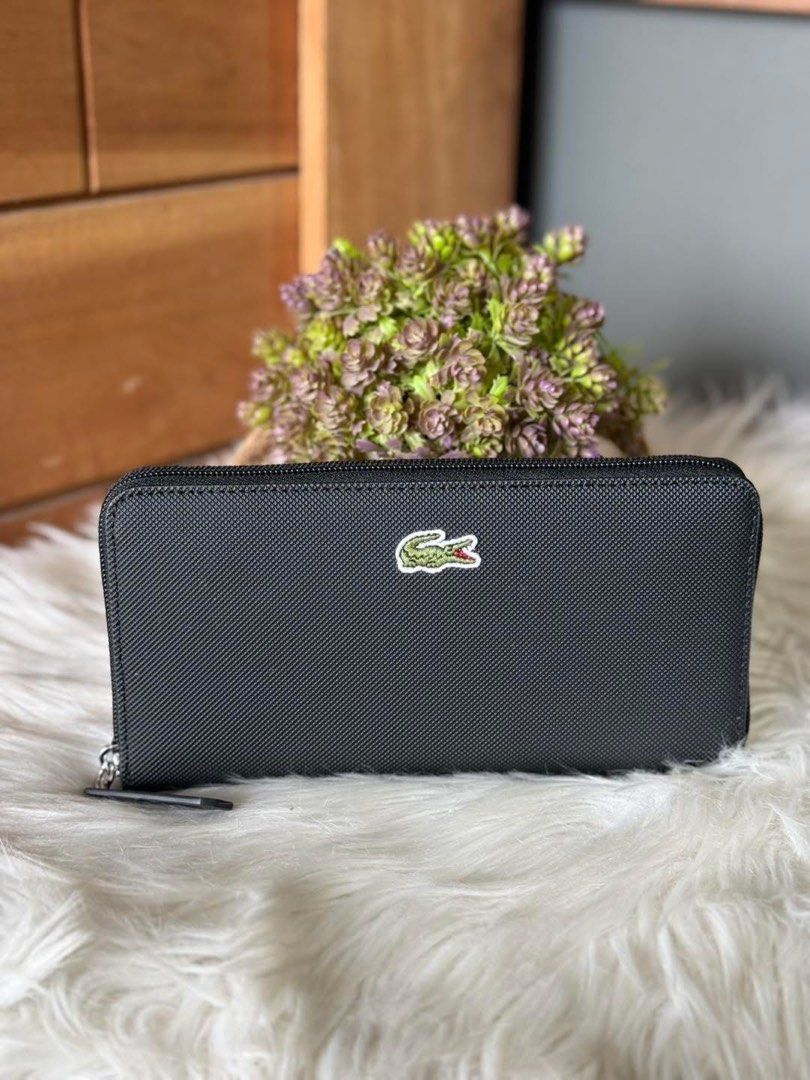 Lacoste Black Zip Around Wallet (Category: Wallets & Card holders) located in Manila. Submitted by clairetot (Listing ID 1422420037, Image 1). Description: Original Lacoste black zip-around wallet. Features the Lacoste logo, textured exterior, zip closure, multiple compartments, and a zippered pocket. Durable material..