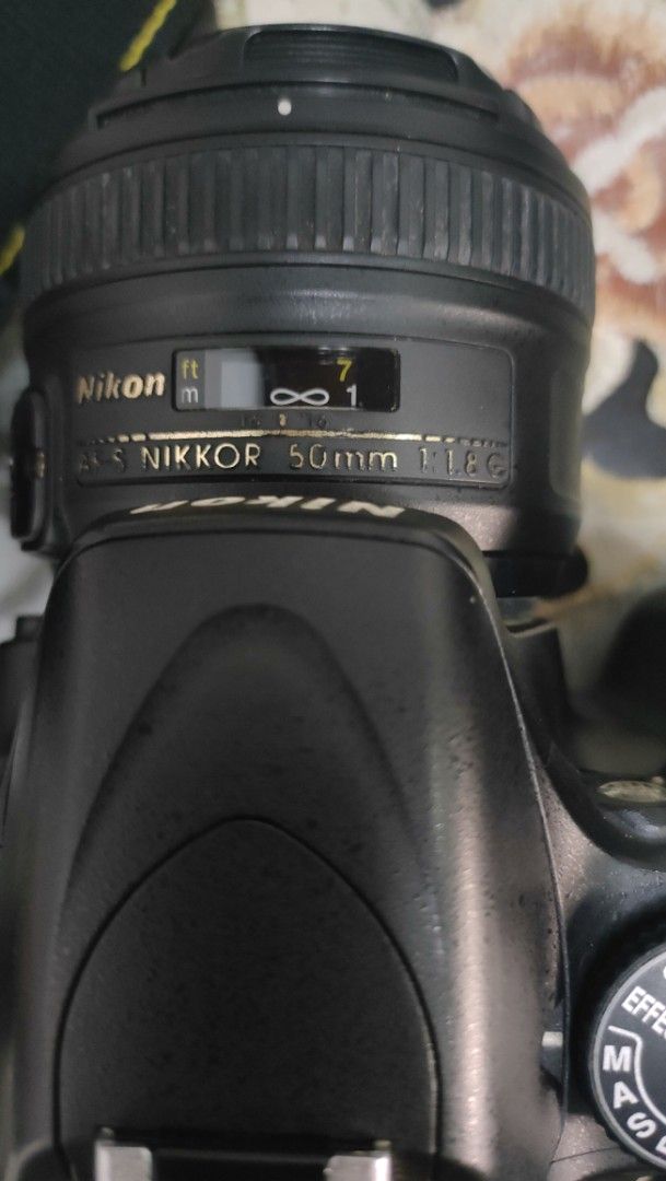 50mm Nikon D5100 DSLR Camera and Accessories (Category: Cameras) located in Taguig. Submitted by fundraising_for_althon (Listing ID 1422393745, Image 3). Description: Includes a Nikon D5100 DSLR camera body, 50mm lense, two batteries, a charger, a memory card, lens caps, and a camera bag. The camera bag has multiple compartments. Also includes a drawstring pouch.