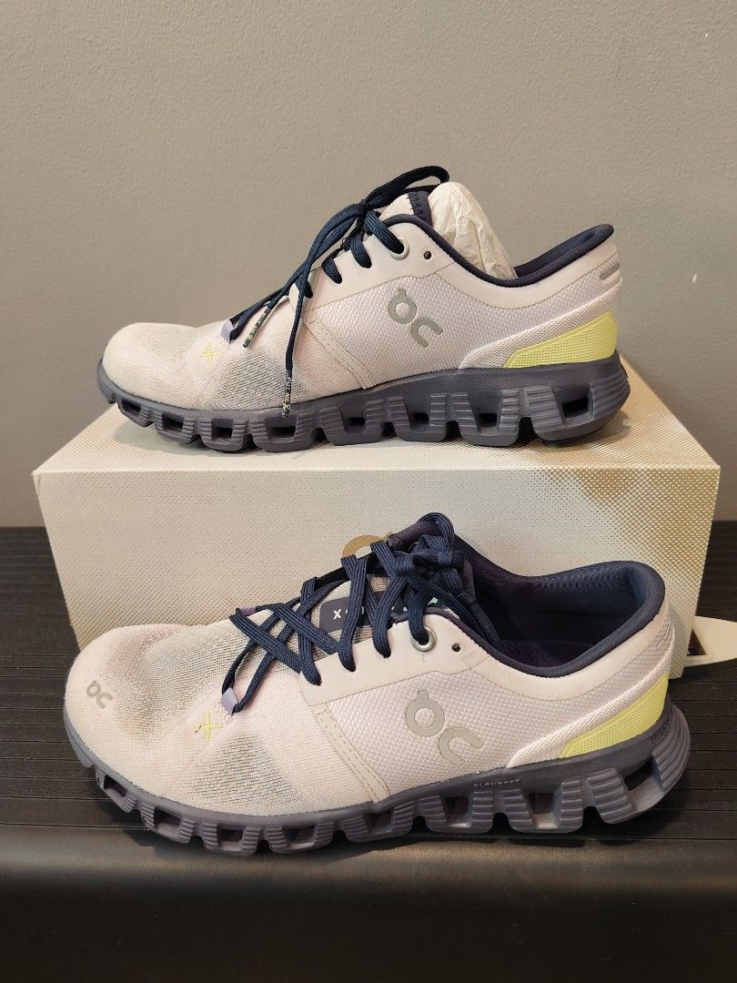 On Cloud X Running Shoes - US W7 (Category: Sneakers) located in Muntinlupa City. Submitted by cezzy82 (Listing ID 1422413320, Image 1). Description: On Cloud X running shoes in white, grey, and navy blue. US W7, EU 38, JP 24. Includes original box. Some sole wear. FLAWS: dirt only sign of usage no damage.