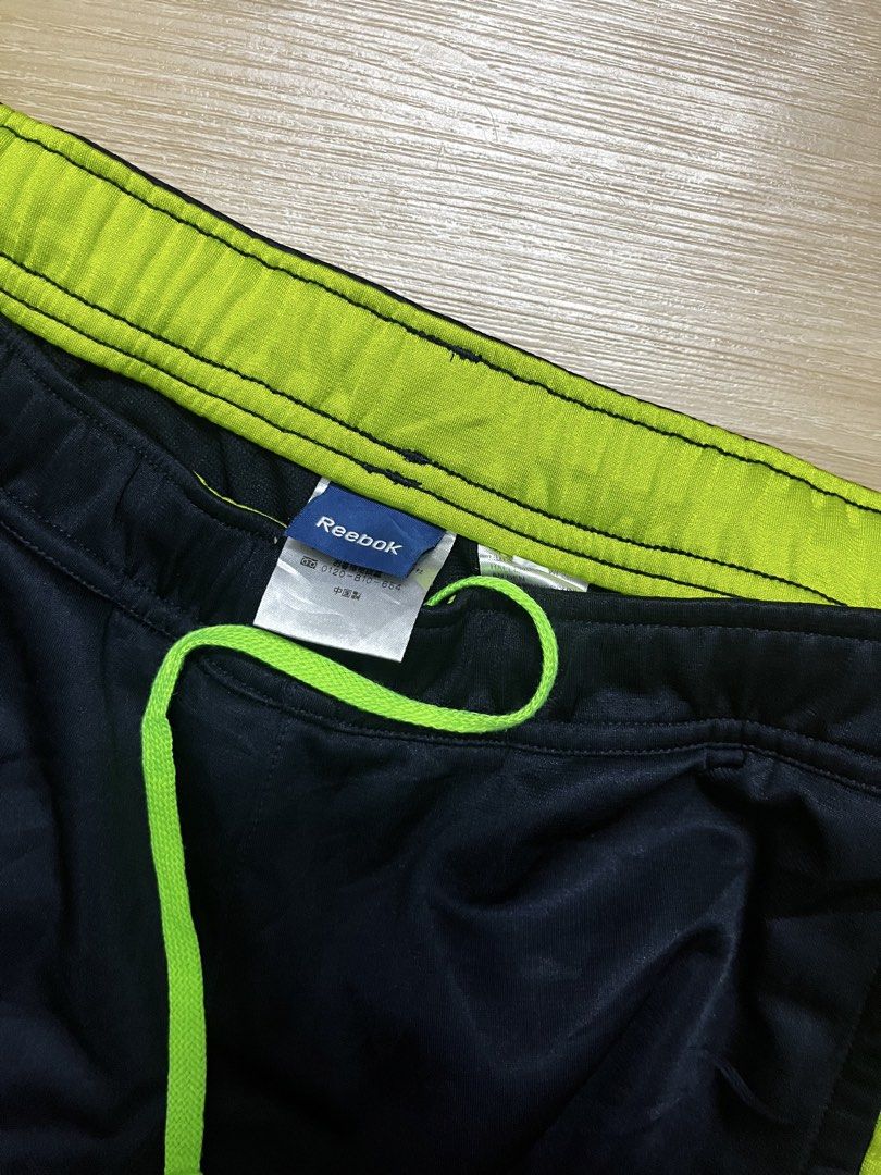 Reebok Fitness Division Track Pants (Category: Joggers) located in Klang. Submitted by aikall (Listing ID 1422503268, Image 3). Description: - Reebok track pants in navy blue with neon green accents. - Drawstring waist for adjustable fit. - Waist size: 30-36 inches. - Length: 40 inches. - Features Reebok Fitness Division logo. - Made of breathable material. - Perfect for workouts or casual wear..