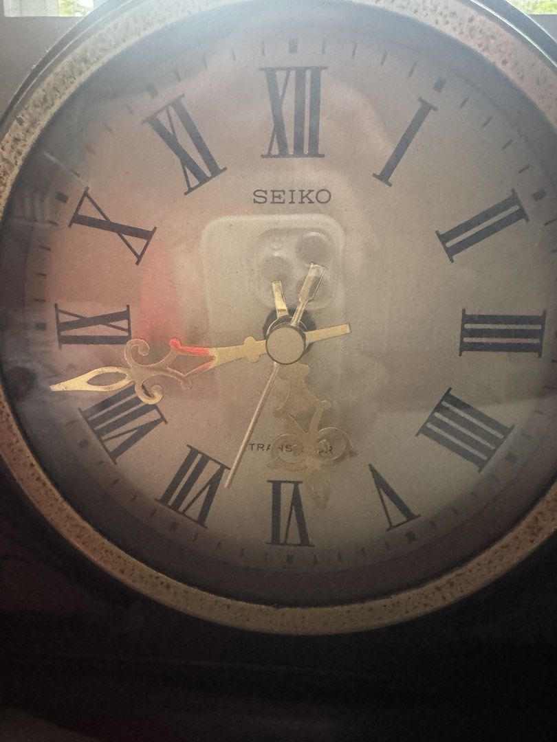 Seiko Table Clock (Category: Clocks) located in Famy. Submitted by bettyque (Listing ID 1422468711, Image 2). Description: - Vintage Seiko table clock - Wooden base - Round clock face - Roman numeral hour markers - Gold-colored hands - Glass cover - Classic design - Suitable for table or shelf display.
