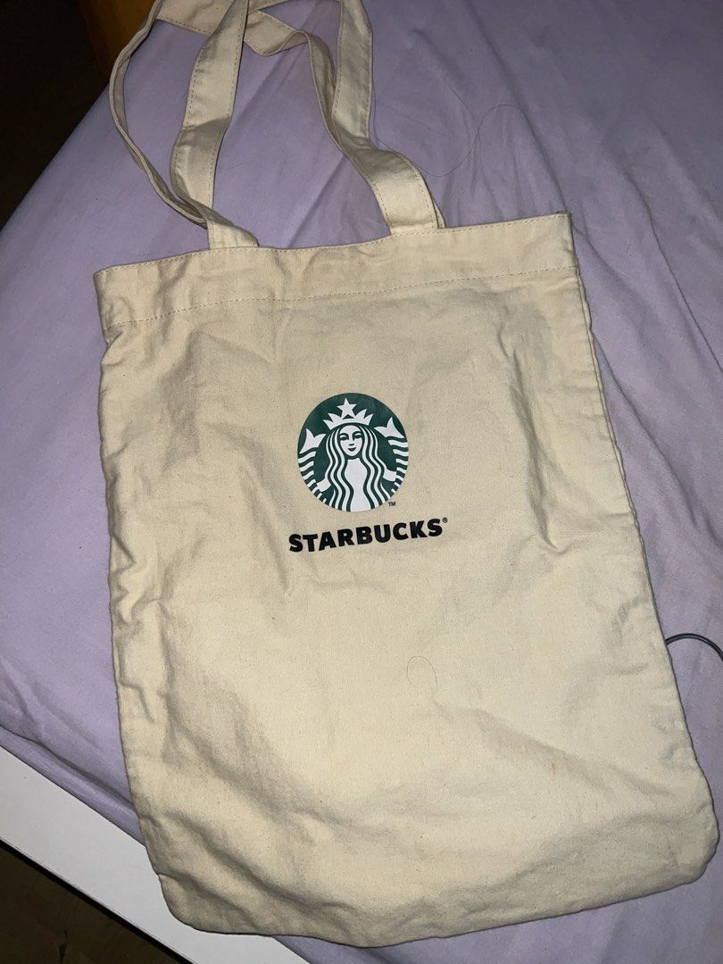 Starbucks Canvas Tote Bag (Category: Tote Bags) located in Cavite. Submitted by cssndrakateg (Listing ID 1422445090, Image 1). Description: - Starbucks canvas tote bag - Beige color - Starbucks logo on the front - Includes an inner pocket - Two handles for carrying.