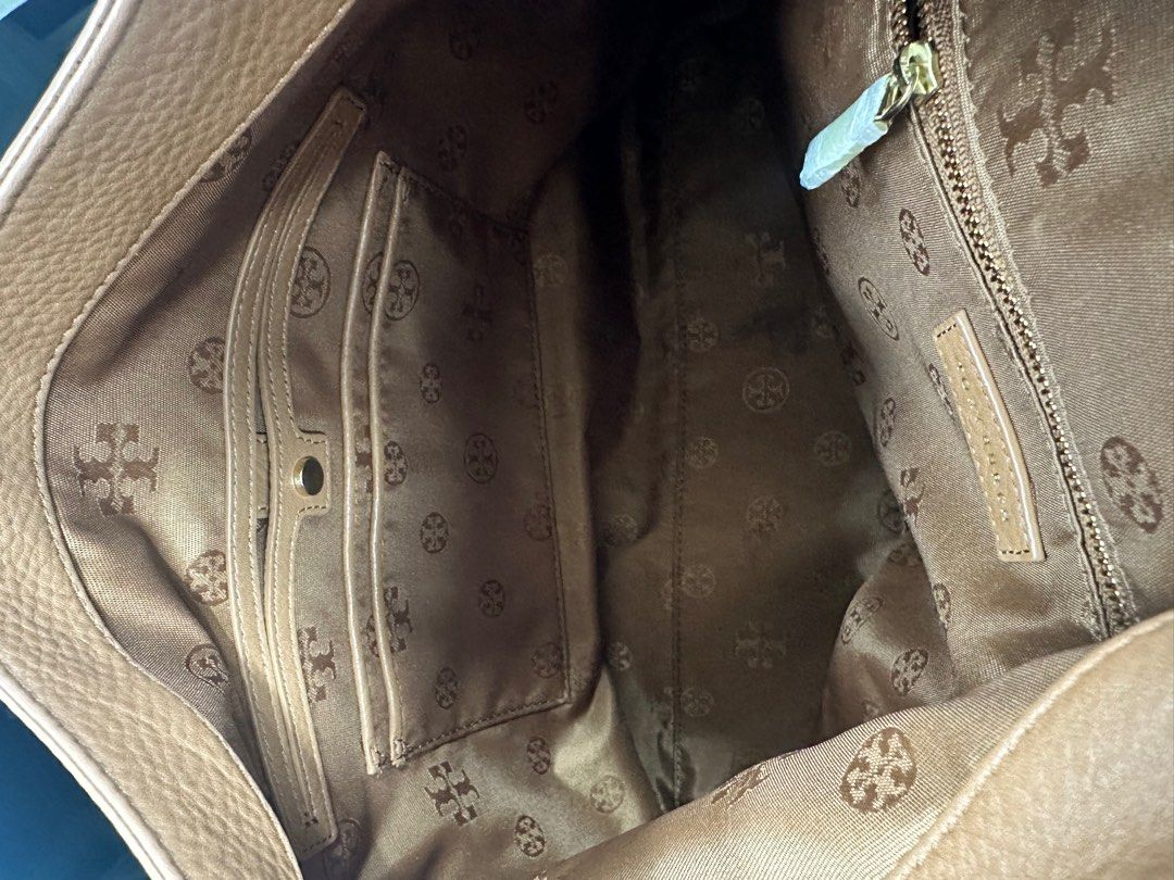Tory Burch Leather Shoulder Bag (Category: Luxury Bags & Wallets) located in Quezon City. Submitted by ririd212 (Listing ID 1422450001, Image 2). Description: - Authentic Tory Burch shoulder bag - Elegant tan color - Spacious interior with multiple pockets - Gold-tone zipper - Signature Tory Burch logo - Patterned interior lining - Crafted from high-quality leather.