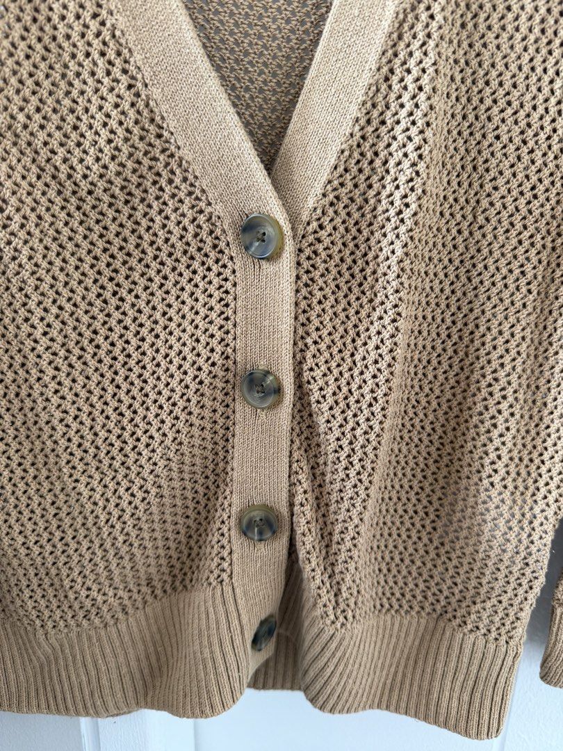 Uniqlo Open Knit Cardigan (Category: Coats, Jackets and Outerwear) located in Taguig. Submitted by BellaC (Listing ID 1422408585, Image 3). Description: - Uniqlo tan cardigan - Open knit design - V-neckline - Button-down closure - Long sleeves - Ribbed hem and cuffs - Size 120 (kids) - Perfect for layering.