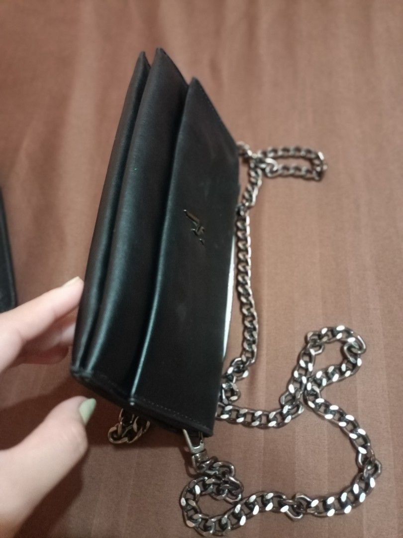 Vera Wang Black Chain Shoulder Bag (Category: Luxury Bags & Wallets) located in Angono. Submitted by wild.lhigaia (Listing ID 1422391929, Image 3). Description: - Black shoulder bag - Chain strap and top handle - Flap closure - Interior zippered pocket and snap closure - Made in Cambodia - Imitation leather shell, polyester lining - Brand logo on front - Silver chain strap.
