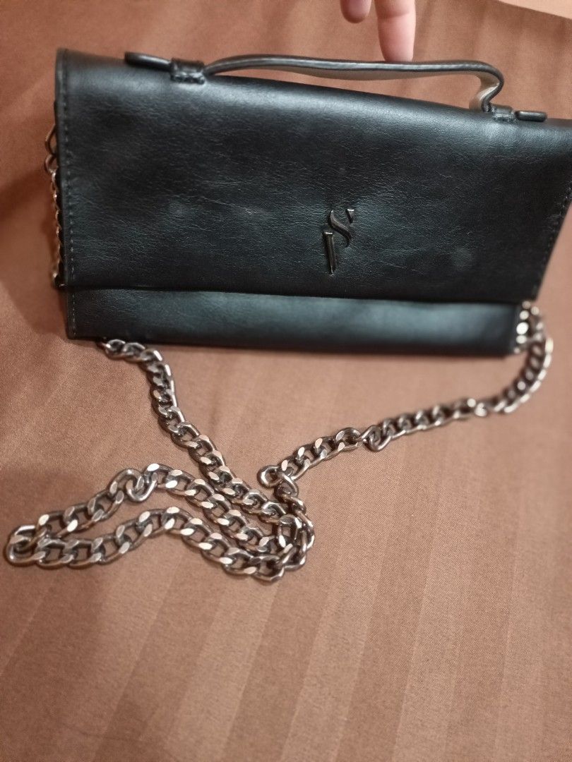 Vera Wang Black Chain Shoulder Bag (Category: Luxury Bags & Wallets) located in Angono. Submitted by wild.lhigaia (Listing ID 1422391929, Image 1). Description: - Black shoulder bag - Chain strap and top handle - Flap closure - Interior zippered pocket and snap closure - Made in Cambodia - Imitation leather shell, polyester lining - Brand logo on front - Silver chain strap.