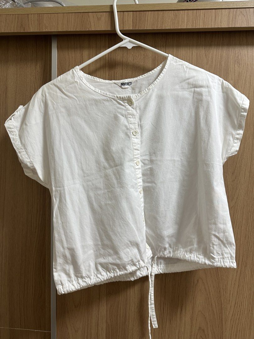 White Button-Up Top (Category: Blouses) located in Santa Rosa. Submitted by krxtnm (Listing ID 1422406748, Image 1). Description: - White button-up top - Round neckline - Short sleeves - Drawstring hem - Casual wear - Versatile design.