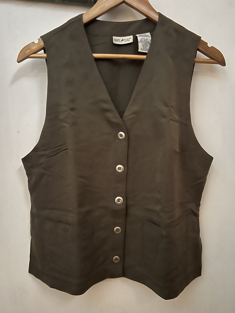 White Stag Olive Green Vest (Category: Vests) located in Cavite. Submitted by cssndrakateg (Listing ID 1422445334, Image 1). Description: - Olive green vest - Brand: White Stag - Features a V-neck design - Button-up closure - Two front pockets - Smooth, possibly synthetic fabric - Size: CH.