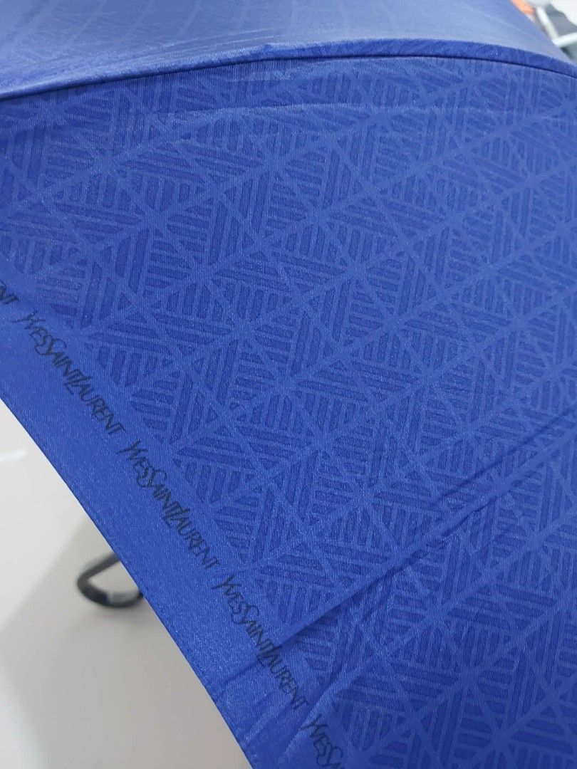 YSL Blue Umbrella (Category: Umbrellas) located in Bayombong. Submitted by Gentlemans_ClosEt (Listing ID 1422484732, Image 3). Description: - YSL umbrella - Vibrant blue color - Unique geometric pattern - Snap closure - Gold-colored handle accent - Includes tag with Japanese characters - Compact, foldable design - Stylish accessory for rainy days.
