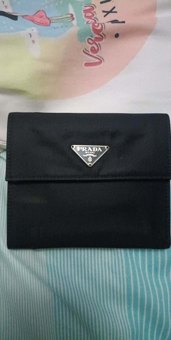 Authentic Prada M170 Tessuto (Category: Luxury Bags & Wallets) located in Quezon City. Submitted by armariodejara (Listing ID 1422682550, Image 1). Description: Decluttering Korea po nabili year 2005 The Prada M170 (or 1M0170) is a vintage-style, black (Nero) tri-fold wallet crafted from durable Prada Tessuto nylon with Saffiano leather trim. It features the iconic enameled metal triangle logo, a snap closure, multiple card slots, a bill compartm