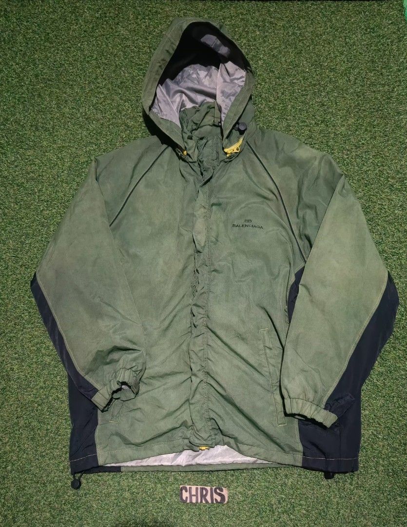 Vtg Balenciaga Hooded (removable Jacket (Category: Coats, Jackets and Outerwear) located in Reina Mercedes. Submitted by SIRCHIVES (Listing ID 1422623088, Image 1). Description: - Balenciaga hooded jacket - Color: Green with black accents - Size: 5 (Xl) - Features: Hood, front zipper, Balenciaga logo - Material: 100% nylon outer shell, 100% polyester lining - Style number: BJ90645-49.