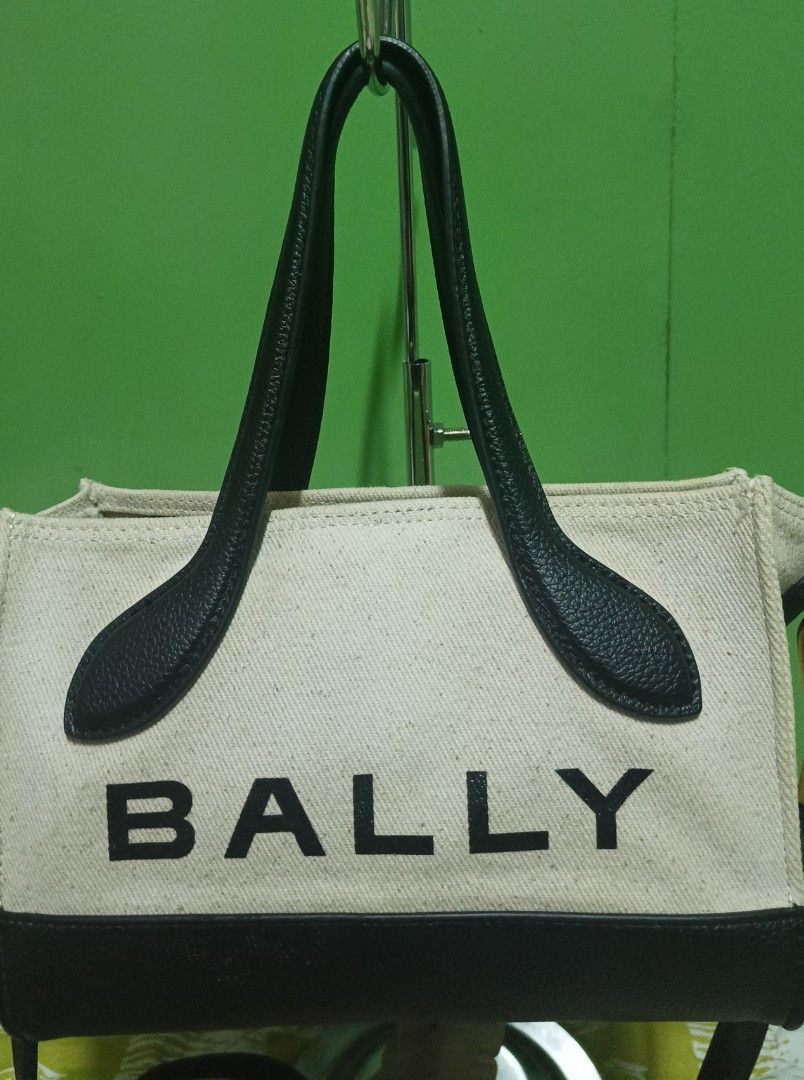 Bally Canvas Tote Bag (Category: Luxury Bags & Wallets) located in Rizal. Submitted by judithtillo19 (Listing ID 1422652662, Image 2). Description: - Bally tote bag - Canvas body with black leather handles and trim - Includes a detachable strap for versatile carrying options - Interior zippered pouch for added organization - Elegant gold-tone clasp - Bally logo prominently displayed - Interior is clean PRELOVED but in excellent condition Malinis 
