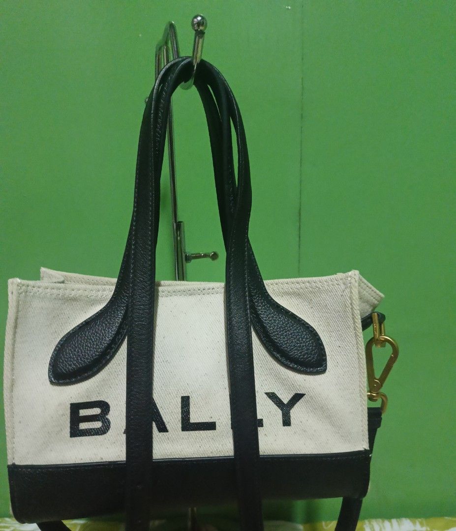 Bally Canvas Tote Bag (Category: Luxury Bags & Wallets) located in Rizal. Submitted by judithtillo19 (Listing ID 1422652662, Image 1). Description: - Bally tote bag - Canvas body with black leather handles and trim - Includes a detachable strap for versatile carrying options - Interior zippered pouch for added organization - Elegant gold-tone clasp - Bally logo prominently displayed - Interior is clean PRELOVED but in excellent condition Malinis 