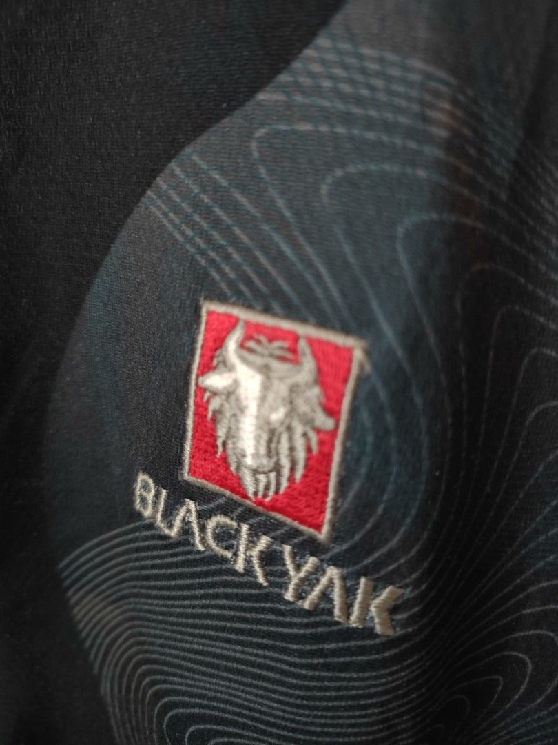Black Yak Cycling Jersey (Category: Activewear) located in Davao. Submitted by calithrift123 (Listing ID 1422601132, Image 2). Description: - Black Yak cycling jersey -Dimension: 21W x 25L - Half-zip closure - Eye-catching design in black, green, and maroon - Features the Black Yak logo on the chest and sleeve - Unique pattern on the back - Fabric with Black Yak brand name pattern - Tag is visible.
