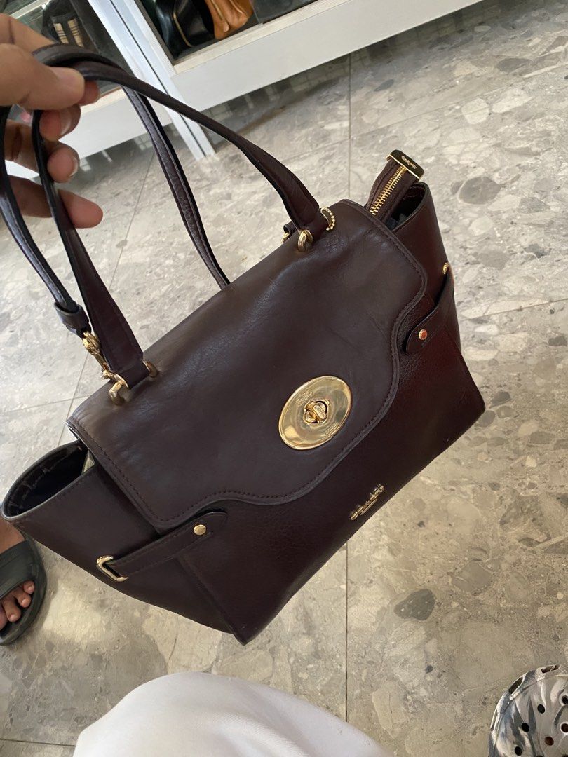 Coach Brown Leather Handbag (Category: Luxury Bags & Wallets) located in Manila. Submitted by thriftvibes324 (Listing ID 1422633869, Image 1). Description: - Authentic Coach handbag - Rich brown color - Classic design with gold-tone turn-lock closure - Interior includes Coach label and "Made in Vietnam" tag - Double handles - Zippered top closure - Matching brown fabric lining.