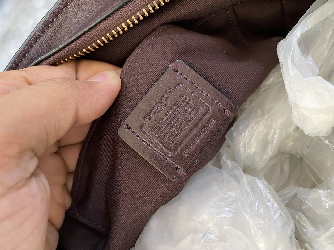 Coach Brown Leather Handbag (Category: Luxury Bags & Wallets) located in Manila. Submitted by thriftvibes324 (Listing ID 1422633869, Image 2). Description: - Authentic Coach handbag - Rich brown color - Classic design with gold-tone turn-lock closure - Interior includes Coach label and "Made in Vietnam" tag - Double handles - Zippered top closure - Matching brown fabric lining.