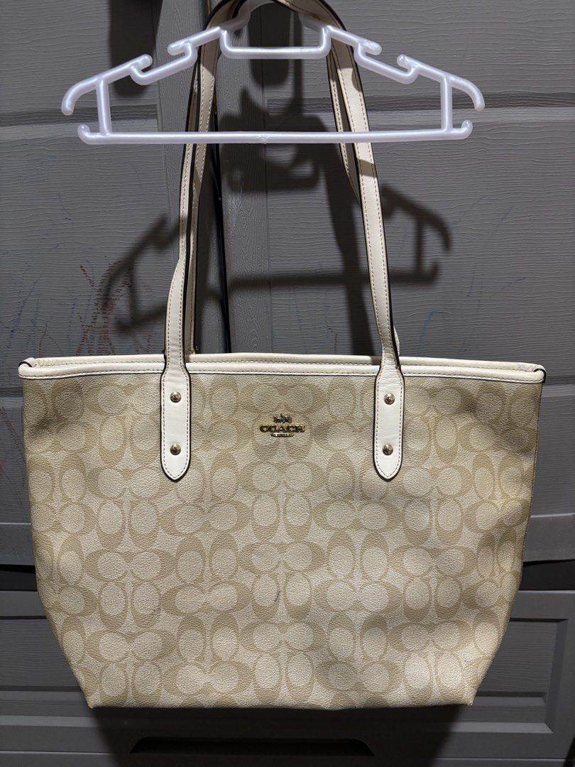 Coach Signature Tote Bag (Category: Luxury Bags & Wallets) located in Manila. Submitted by jjrdz (Listing ID 1422668428, Image 1). Description: - Coach tote bag - Signature pattern - Cream-colored handles and trim - Gold-tone hardware - Interior Coach label - Minor mark on exterior - Some wear on handles.