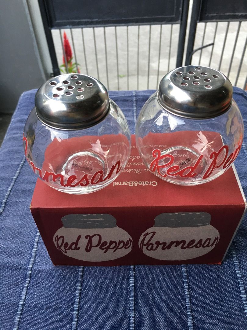 Crate & Barrel Pizza Shaker Set (Category: Other Kitchenware & Tableware) located in Calamba. Submitted by marjoh29436 (Listing ID 1422682292, Image 2). Description: Crate & Barrel Pizza Shaker Set. Includes two glass shakers with metal lids, labeled "Red Pepper" and "Parmesan". Comes with the original box. The box indicates the set is made exclusively for Crate & Barrel. Perfect for adding flavor to your homemade pizzas! Not USED, in excellent c