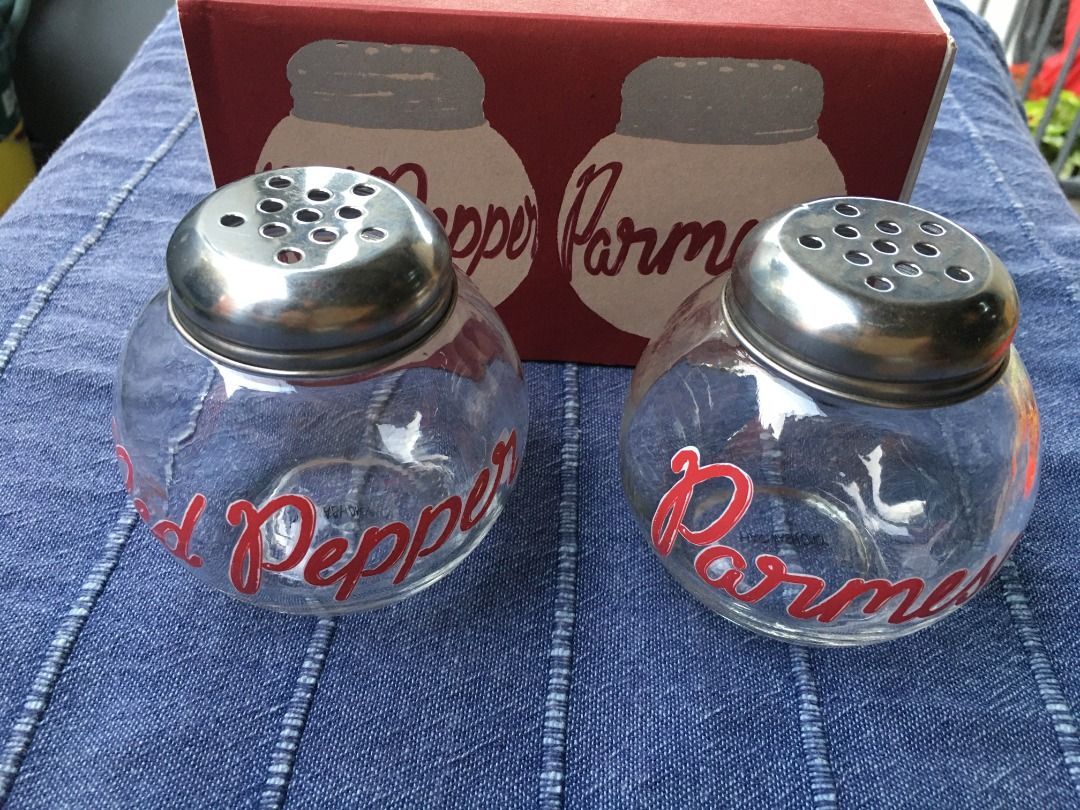 Crate & Barrel Pizza Shaker Set (Category: Other Kitchenware & Tableware) located in Calamba. Submitted by marjoh29436 (Listing ID 1422682292, Image 3). Description: Crate & Barrel Pizza Shaker Set. Includes two glass shakers with metal lids, labeled "Red Pepper" and "Parmesan". Comes with the original box. The box indicates the set is made exclusively for Crate & Barrel. Perfect for adding flavor to your homemade pizzas! Not USED, in excellent c