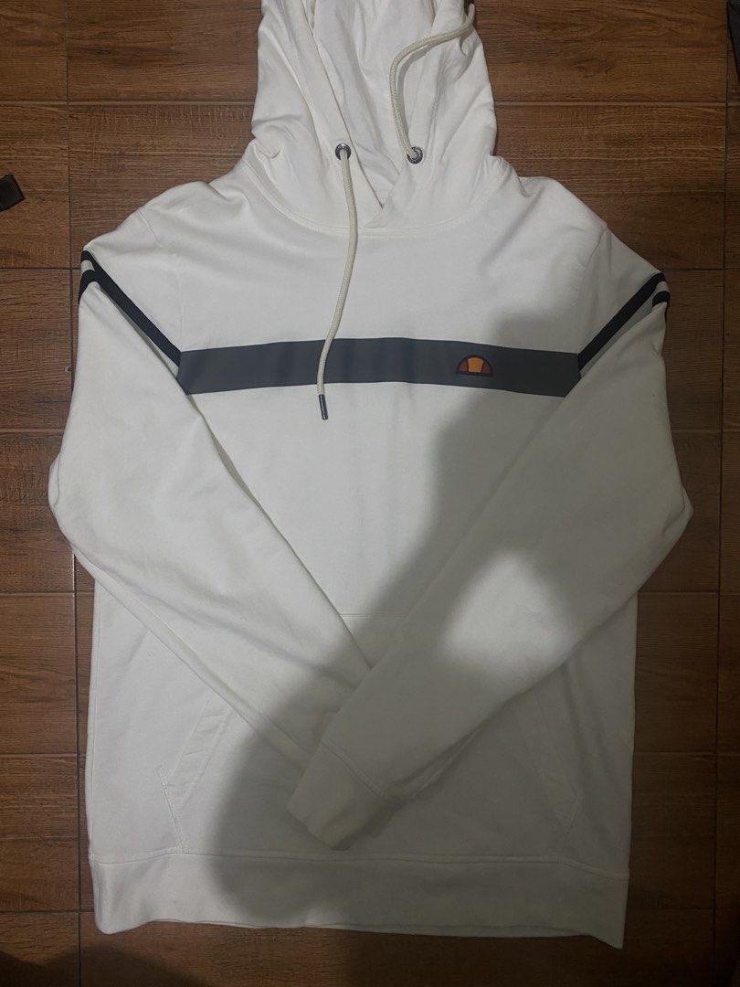 Ellesse White Hoodie (Category: Hoodies) located in Manila. Submitted by decluttering14 (Listing ID 1422556288, Image 1). Description: - Ellesse hoodie - Size: L - Features: Grey stripe across chest and sleeves, Ellesse logo - Made in: Indonesia - Material: 100% cotton.