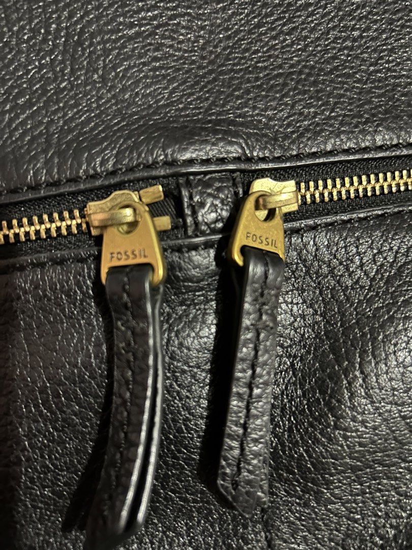 Fossil Black Leather Crossbody Bag (Category: Cross-body Bags) located in Muntinlupa City. Submitted by beeminees (Listing ID 1422713202, Image 3). Description: - Genuine Erin Fossil crossbody bag - Black leather - Top handle and adjustable shoulder strap - Exterior: Two zippered pockets - Interior: Zippered pocket and Fossil logo patch - Magnetic snap closure - Includes original tags - Minor wear on bag corners.