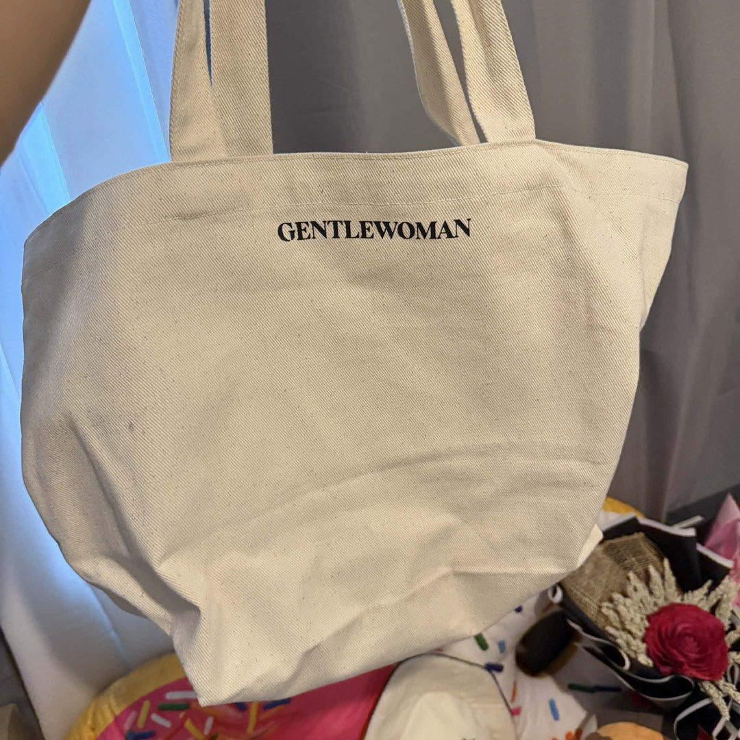 Gentlewoman Tote Bag (Category: Tote Bags) located in Manila. Submitted by perlitas (Listing ID 1422545161, Image 2). Description: Gentlewoman tote bag in cream color. Features a front pocket and the brand name printed on the front. The bag has a spacious interior and sturdy handles. The back of the bag has the brand name printed. Perfect for everyday use..