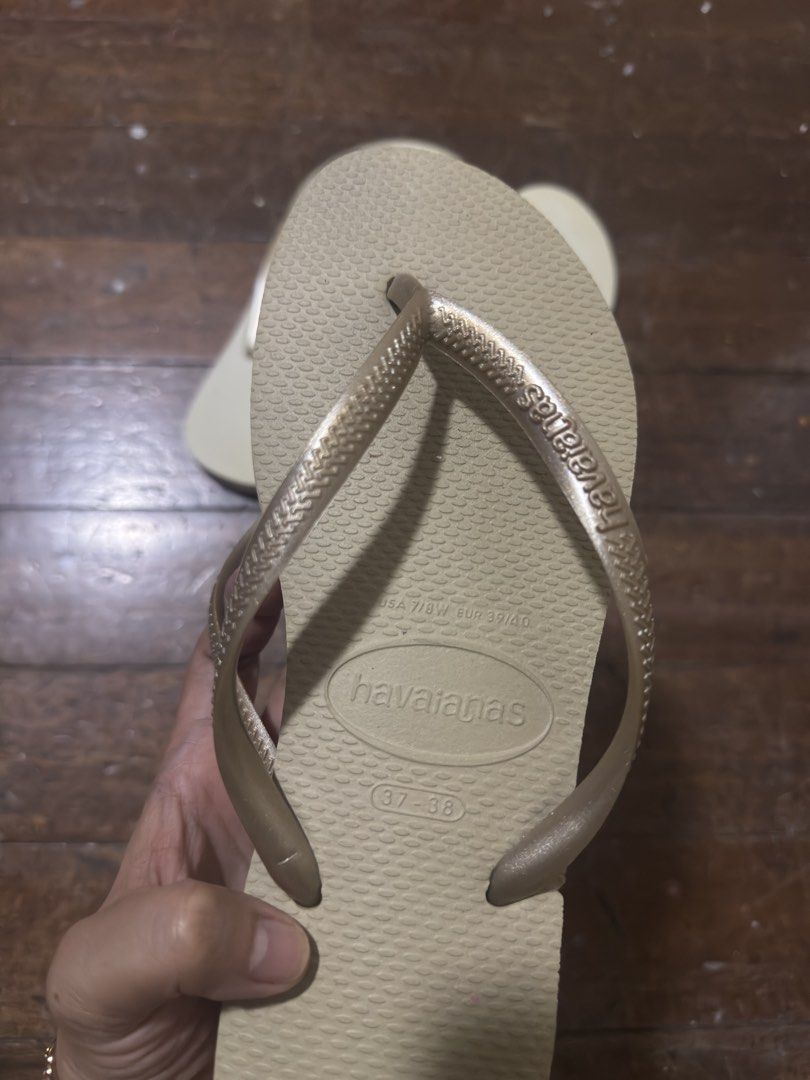 Havaianas Flip-flops (Category: Slippers and slides) located in Manila. Submitted by jemerrysudlon16 (Listing ID 1422591339, Image 2). Description: Pair of Havaianas flip-flops. One pair is beige with gold straps, size 37-38. The other pair is light beige with gold straps. Both pairs have the Havaianas logo on the straps and soles. The soles have a textured pattern for grip. 24 cm 700 each .