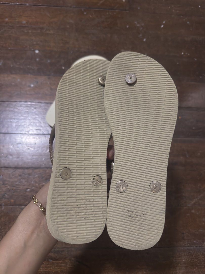 Havaianas Flip-flops (Category: Slippers and slides) located in Manila. Submitted by jemerrysudlon16 (Listing ID 1422591339, Image 3). Description: Pair of Havaianas flip-flops. One pair is beige with gold straps, size 37-38. The other pair is light beige with gold straps. Both pairs have the Havaianas logo on the straps and soles. The soles have a textured pattern for grip. 24 cm 700 each .
