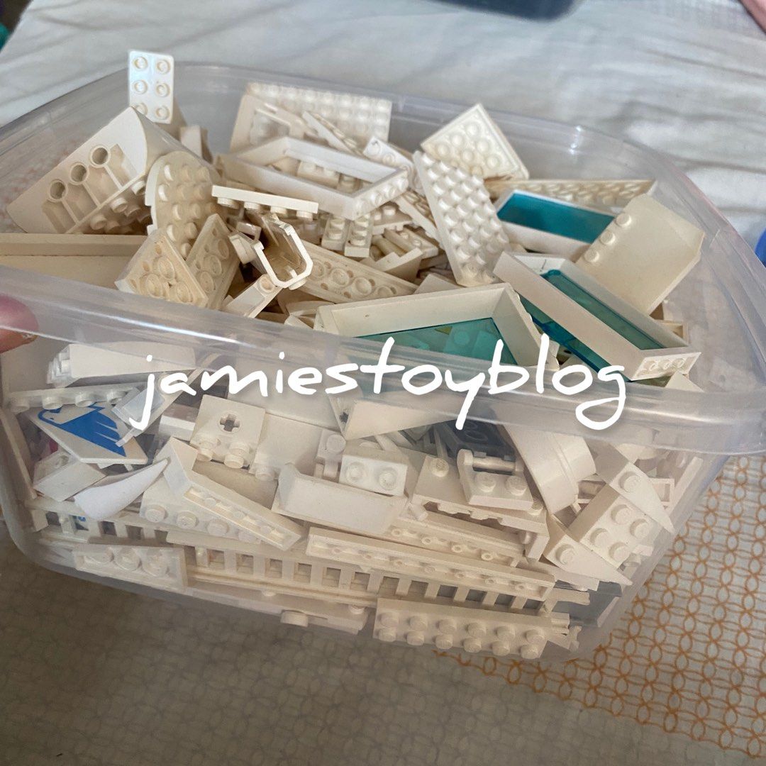 LEGO White Bricks and Parts - TAKE ALL (Category: Lego & Building Sets) located in Quezon City. Submitted by ohitsninja (Listing ID 1422598454, Image 1). Description: - Assortment of white LEGO bricks and parts. - Includes various shapes and sizes (plates, bricks, etc.). - Features some pieces with transparent blue elements. - Stored in a clear plastic container. - As is Pay by Gcash Delivery shouldered by buyer I DO NOT USE COD OR SCO..