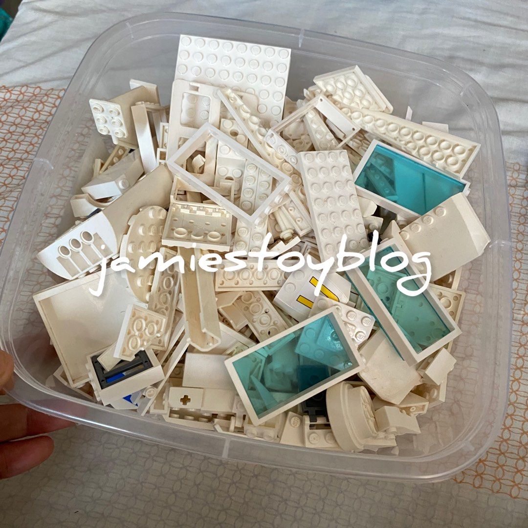 LEGO White Bricks and Parts - TAKE ALL (Category: Lego & Building Sets) located in Quezon City. Submitted by ohitsninja (Listing ID 1422598454, Image 2). Description: - Assortment of white LEGO bricks and parts. - Includes various shapes and sizes (plates, bricks, etc.). - Features some pieces with transparent blue elements. - Stored in a clear plastic container. - As is Pay by Gcash Delivery shouldered by buyer I DO NOT USE COD OR SCO..
