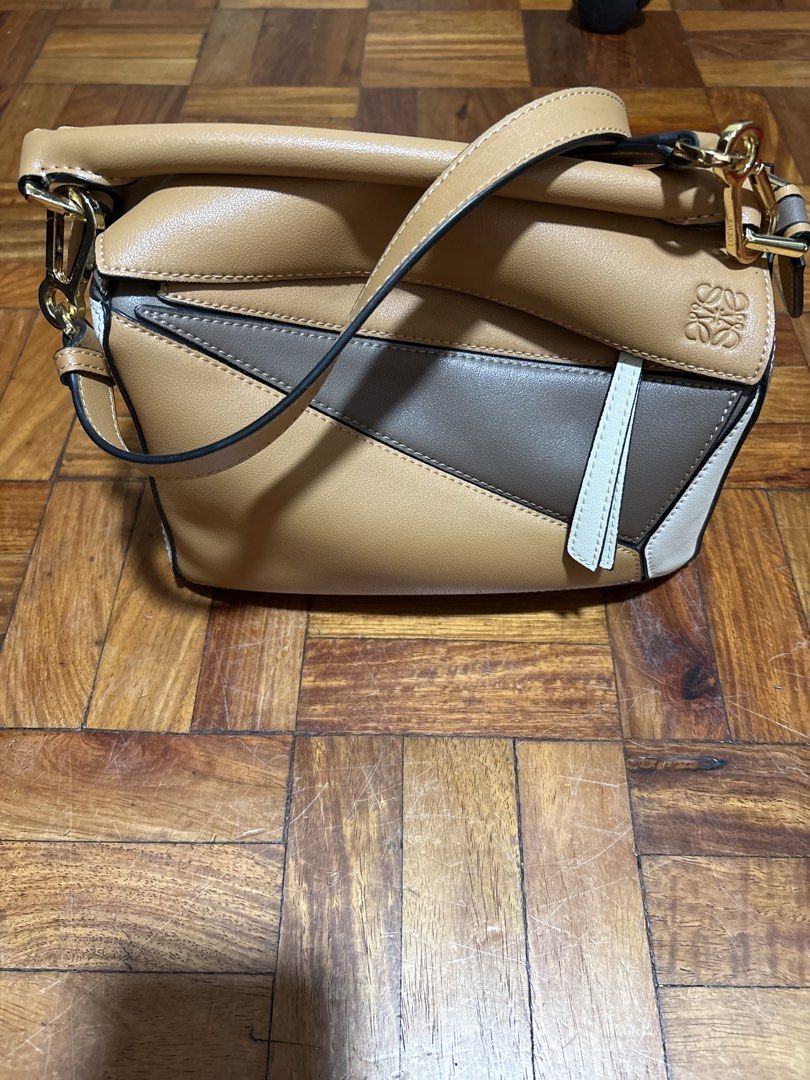 Loewe Puzzle Mini Bag (Category: Luxury Bags & Wallets) located in Mandaluyong City. Submitted by carlaannemarie (Listing ID 1422585963, Image 3). Description: - Loewe Puzzle Mini Bag - Color: Tan, Brown, White - Unique geometric design - Top handle and detachable shoulder strap - Gold-tone hardware - Made of leather - Loewe logo visible.
