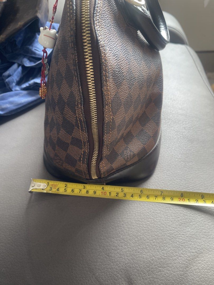 Louis Vuitton Alma Damier Ebene Handbag (Category: Luxury Bags & Wallets) located in San Juan City. Submitted by nhelsky_c (Listing ID 1422567694, Image 2). Description: - japan sourceLouis Vuitton Alma handbag - Damier Ebene canvas - Zip closure - Rolled leather handles - Spacious interior with slip pocket - Brown leather base and trim - Includes decorative charm - Dimensions: Approx. 9" height x 12" width.