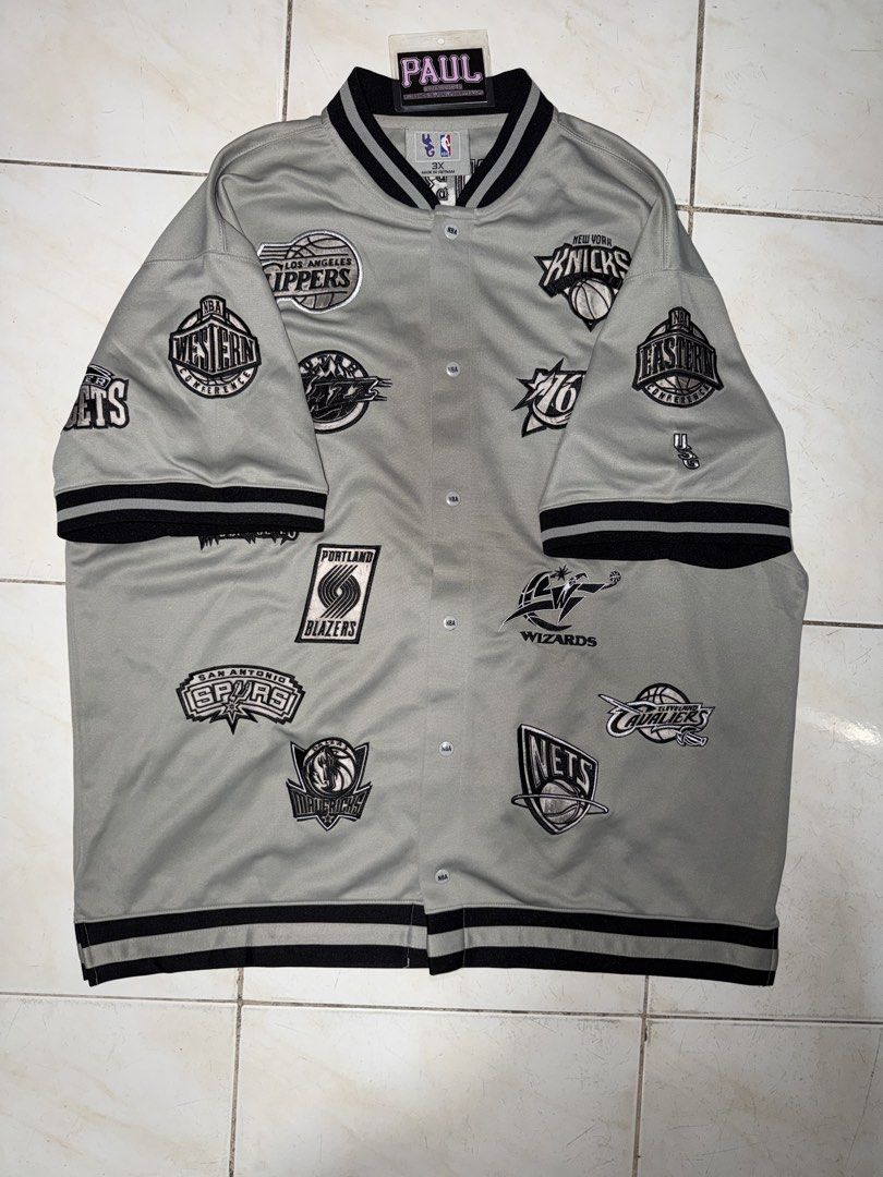 NBA Team Logo Jacket (Category: Coats, Jackets and Outerwear) located in Quezon City. Submitted by bigbad_p (Listing ID 1422690655, Image 3). Description: - Vintage NBA jacket - Features multiple NBA team logos - Gray with black logos and trim - Button-up front - Short sleeves - Black and white striped trim - Retro style.