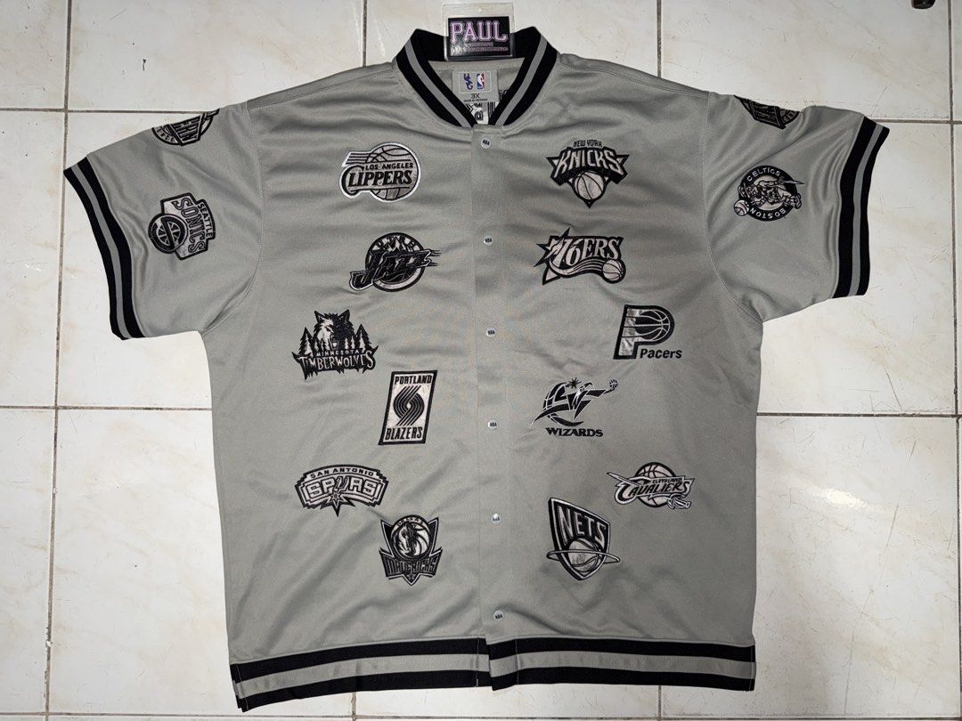 NBA Team Logo Jacket (Category: Coats, Jackets and Outerwear) located in Quezon City. Submitted by bigbad_p (Listing ID 1422690655, Image 1). Description: - Vintage NBA jacket - Features multiple NBA team logos - Gray with black logos and trim - Button-up front - Short sleeves - Black and white striped trim - Retro style.