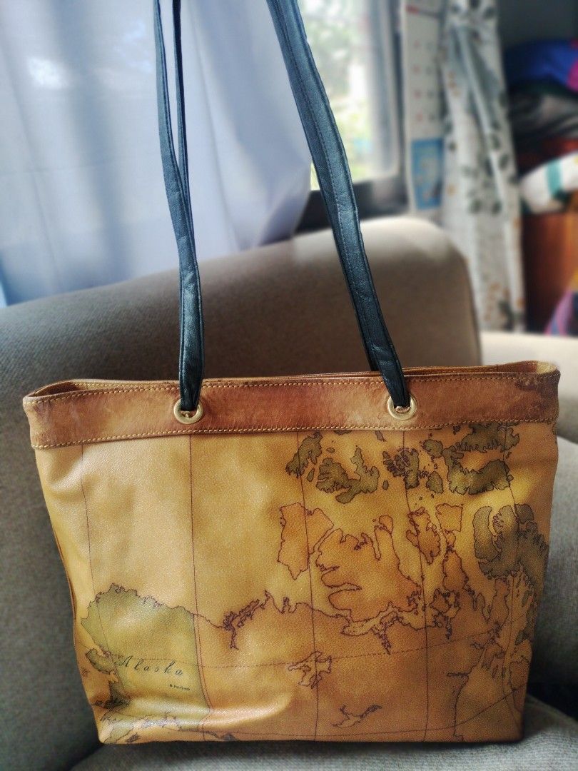 Prima Classe Map Print Tote Bag (Category: Luxury Bags & Wallets) located in Buenavista. Submitted by yasi11 (Listing ID 1422588881, Image 2). Description: - Prima Classe tote bag with iconic map print - Black handles and secure zip closure - Interior includes a branded tag and a zippered pocket - Crafted from leather - Shows some wear on the top trim.