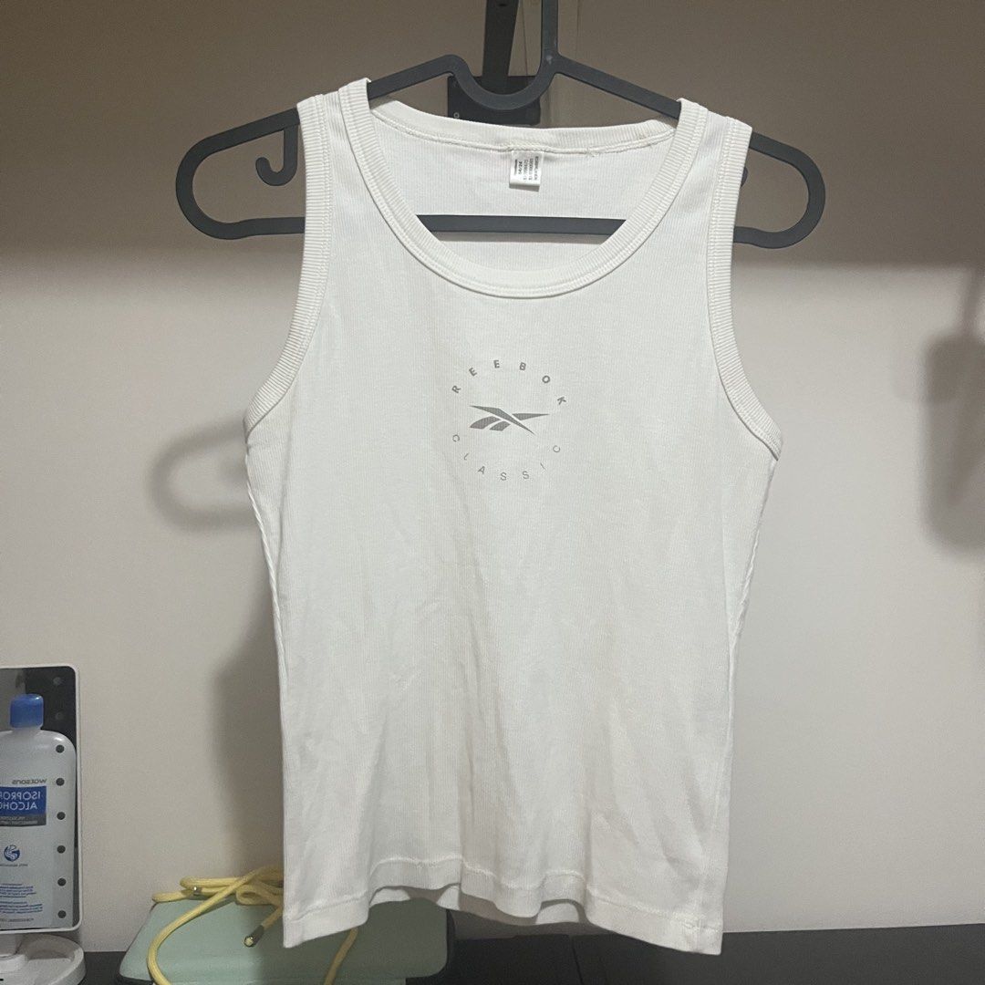 Reebok Classic Tank Top off white (Category: Sleeveless) located in Mandaluyong City. Submitted by raspb (Listing ID 1422606267, Image 1). Description: Original from sports central -Round neckline - Sleeveless design - Reebok logo on front - Made of ribbed fabric - Versatile for casual or workout wear.