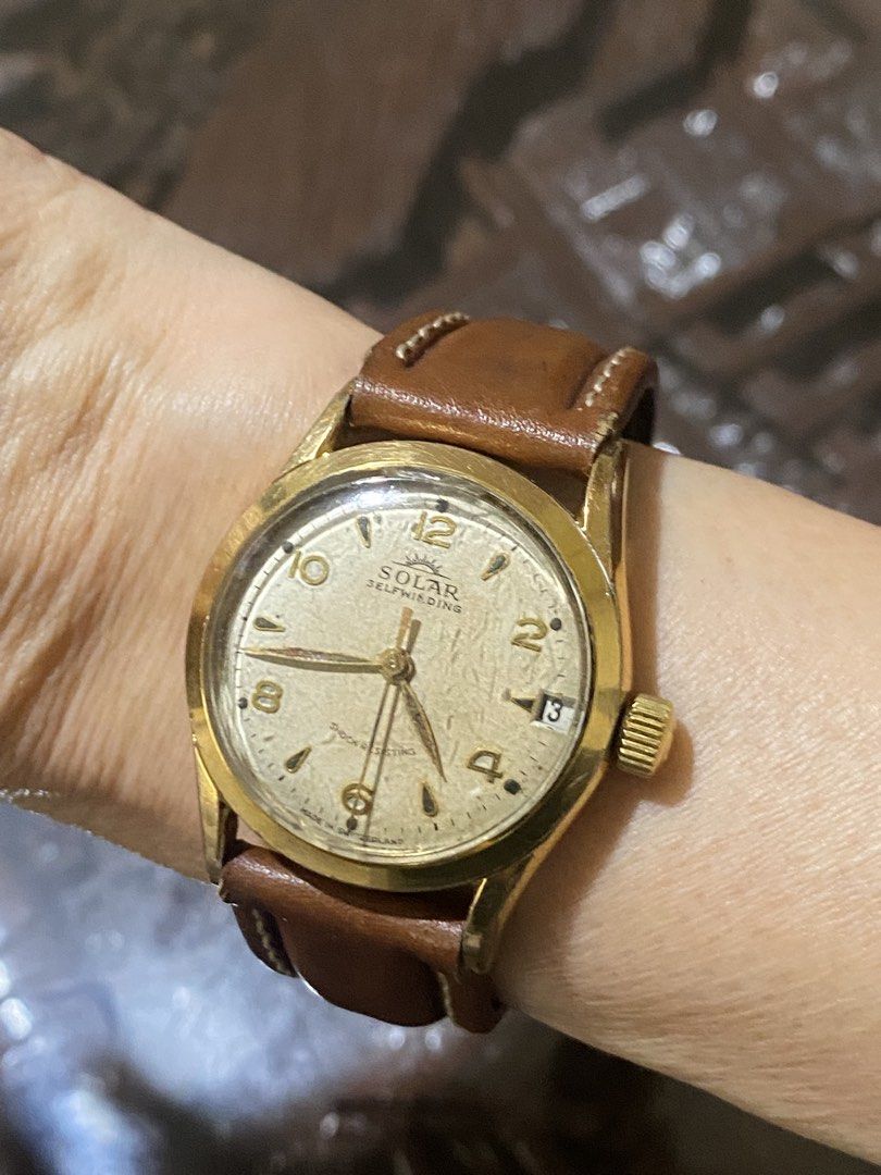 Solar Selfwinding Vintage Watch (Category: Luxury Watches) located in Manila. Submitted by roseluxuryitems (Listing ID 1422585389, Image 3). Description: Omega Speedmaster Solar Impulse Self Winding Shock Resisting Vintage Solar Selfwinding watch with a gold-toned case and a brown leather strap. The watch face is a light cream color with gold-toned numerals and hands. It features a date display at the 3 o'clock position and is marked "Shock Resis