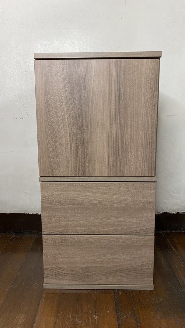 Wooden Cabinet with Drawers (Category: Shelves, Cabinets & Racks) located in Quezon City. Submitted by joannerc (Listing ID 1422548680, Image 1). Description: - Wooden cabinet - Two-door upper section - Two drawers below - Light wood grain finish - Modular design (top and bottom sections may separate) - Suitable for various rooms.