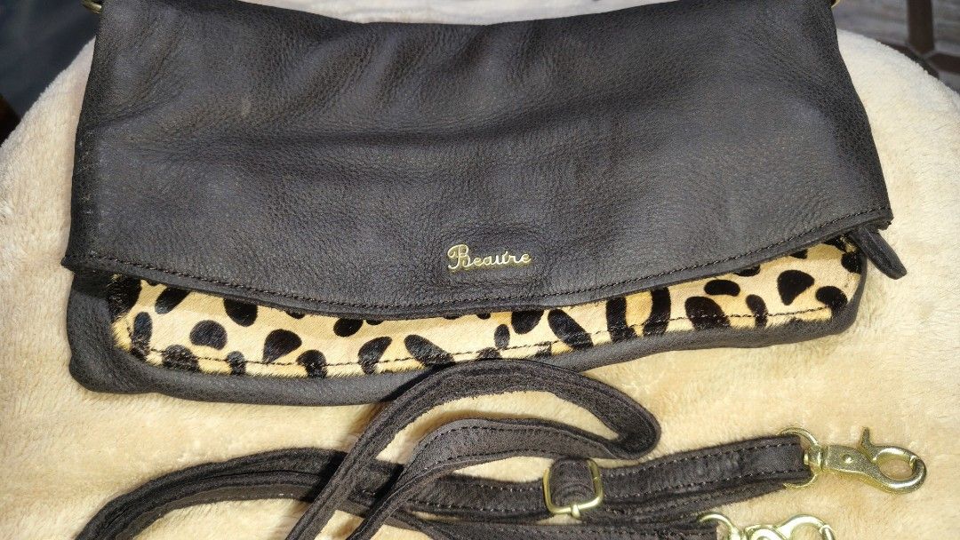 Beaure Brown Leather Sling/Shoulder bag with Leopard Print (Category: Luxury Bags & Wallets) located in Tanza. Submitted by declutterolshoppe (Listing ID 1422835227, Image 1). Description: - Stylish brown leather sling/shoulder bag - Unique leopard print accent - Fold-over flap with magnetic snap - Detachable shoulder strap - Interior zippered pocket - Spacious main compartment - Elegant gold-toned hardware - Perfect for everyday or special event