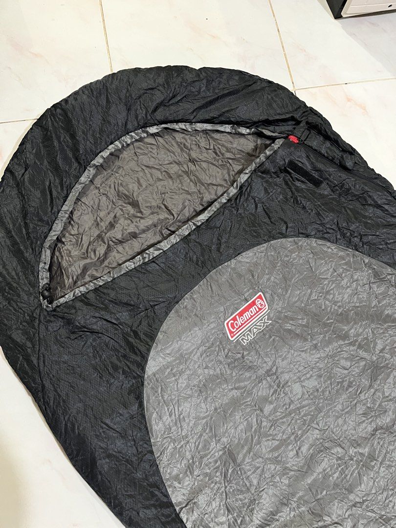 Coleman MAX Sleeping Bag (Category: Hiking & Camping) located in Batangas. Submitted by seiferdg (Listing ID 1422814502, Image 2). Description: - Coleman MAX sleeping bag - Black and gray color scheme - Features a zipper closure - Includes care instructions tag - Ideal for camping and outdoor activities.