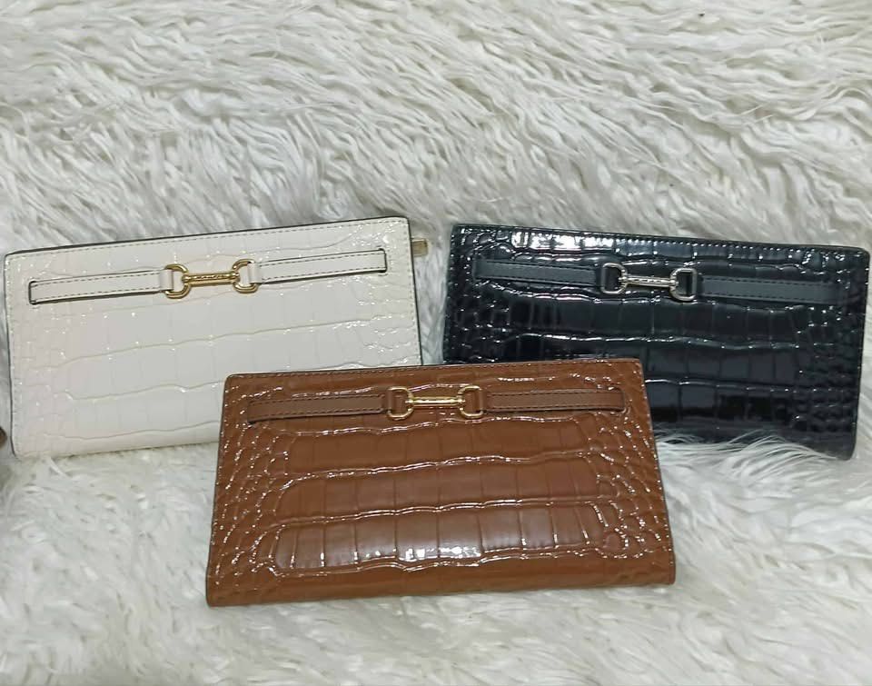 Crocodile Embossed Wallet (Category: Luxury Bags & Wallets) located in Abucay. Submitted by lovieauthenticmerchandise (Listing ID 1422783581, Image 1). Description: - Crocodile-embossed long wallet - Available colors: white, black, brown - Secure clasp closure - Sleek, classic design - Glossy finish - Holds cards and cash.