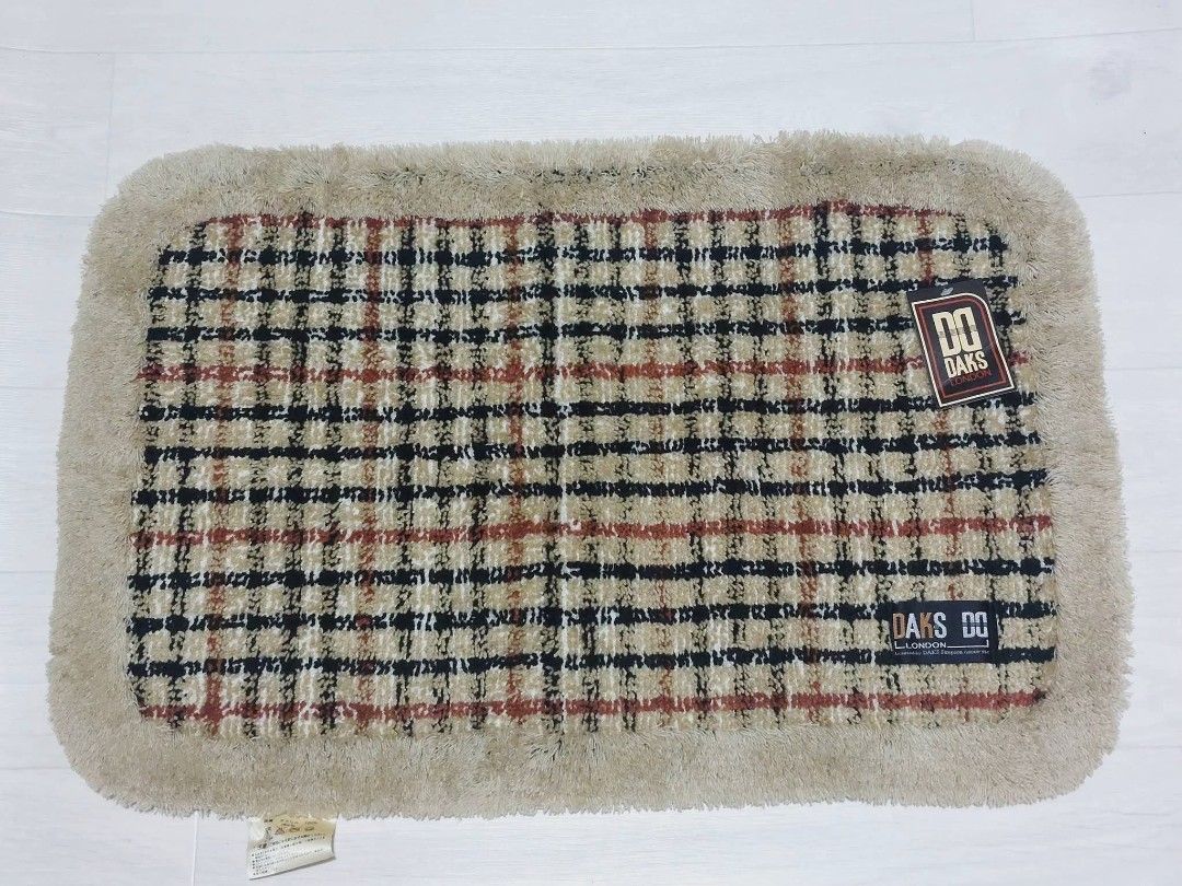 DAKS London Bath Mat (Category: Carpets, Mats & Flooring) located in Muntinlupa City. Submitted by JapanItemsOnTheGo (Listing ID 1422801056, Image 2). Description: DAKS London bath mat with a beige, black, and red plaid pattern. The mat has a soft, fringed border. The tag indicates the size is 48 x 70 cm and made of 100% acrylic. The color is beige. Made in Japan. Daks L0ndon Floor Mat Bnew no box.