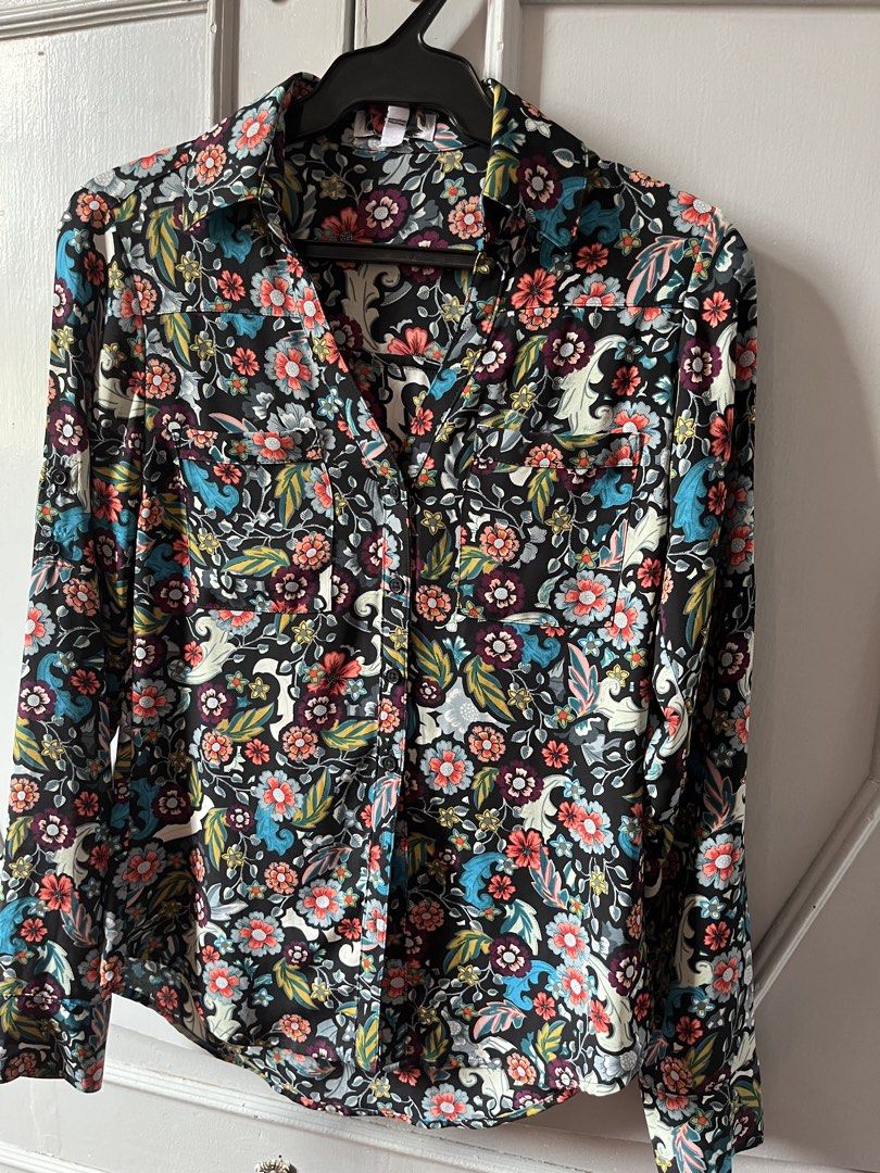 Floral Print Long Sleeve Blouse (Category: Blouses) located in Manila. Submitted by tinnie71 (Listing ID 1422770308, Image 1). Description: - Long-sleeved blouse - Features a vibrant floral print in blue, orange, and white - Black background - Collared neckline - Two chest pockets - Buttoned cuffs.