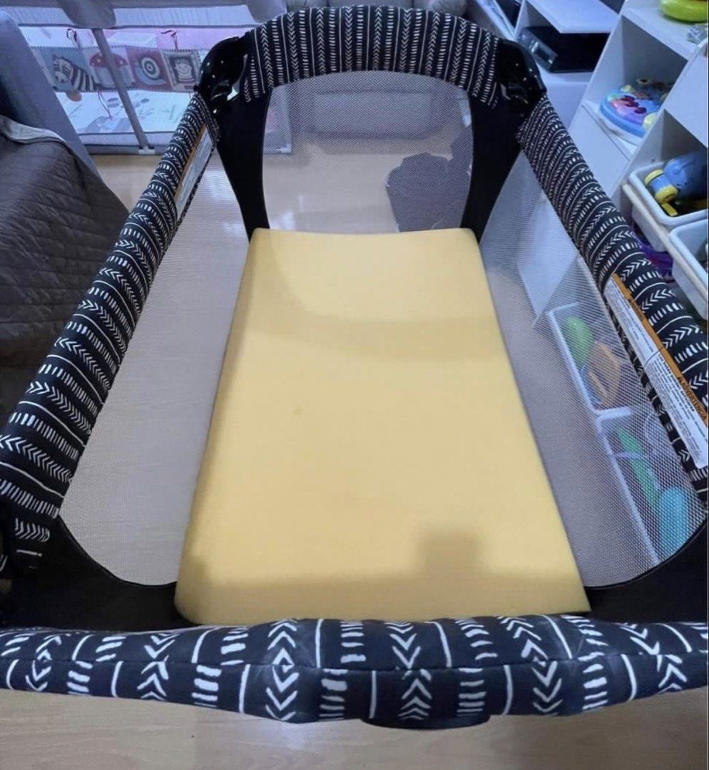 Graco Pack 'n Play Playard with mattress 2 organic bedsheets (Category: Cots & Cribs) located in Mandaluyong City. Submitted by katiecm (Listing ID 1422801149, Image 2). Description: - Graco Pack 'n Play playard - Stylish black and white patterned design - Includes mattress and carrying bag - Mesh sides for visibility and ventilation - Ready for immediate use - Graco logo visible.
