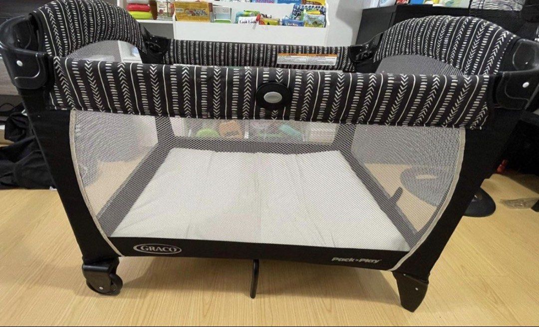 Graco Pack 'n Play Playard with mattress 2 organic bedsheets (Category: Cots & Cribs) located in Mandaluyong City. Submitted by katiecm (Listing ID 1422801149, Image 1). Description: - Graco Pack 'n Play playard - Stylish black and white patterned design - Includes mattress and carrying bag - Mesh sides for visibility and ventilation - Ready for immediate use - Graco logo visible.