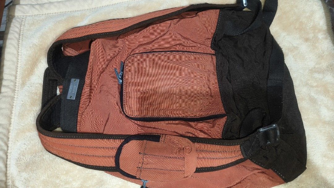 HEDGREN Backpack - Orange and Black (Category: Backpacks) located in Tanza. Submitted by declutterolshoppe (Listing ID 1422825254, Image 3). Description: Herbert backpack features a vibrant orange and black color scheme. It has multiple compartments, including a front pocket and a main compartment with a drawstring closure. The backpack includes adjustable shoulder straps and a top handle. It also has a side pocket and a small pocket on the shoul