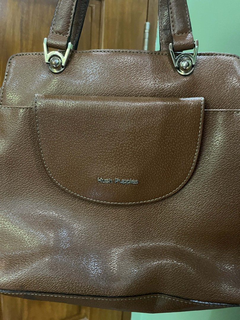 Hush Puppies Brown Handbag (Category: Luxury Bags & Wallets) located in Orani. Submitted by dejaniuph (Listing ID 1422803284, Image 3). Description: - Brown Hush Puppies handbag - Front pocket - Top handle design - Zippered closure on the back - Multiple interior compartments - Branded lining - Silver-toned hardware - Hush Puppies logo on front pocket.