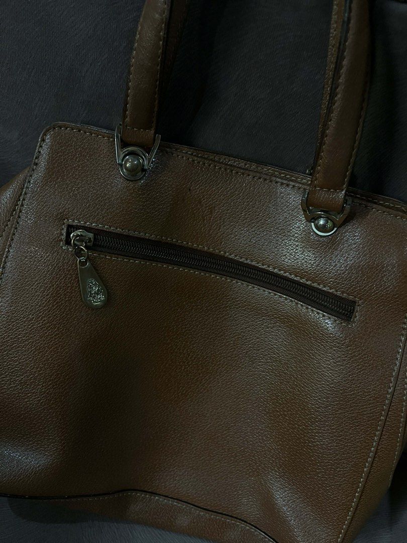 Hush Puppies Brown Handbag (Category: Luxury Bags & Wallets) located in Orani. Submitted by dejaniuph (Listing ID 1422803284, Image 2). Description: - Brown Hush Puppies handbag - Front pocket - Top handle design - Zippered closure on the back - Multiple interior compartments - Branded lining - Silver-toned hardware - Hush Puppies logo on front pocket.