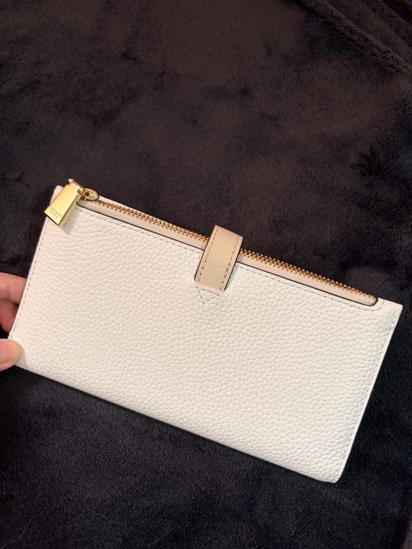 Kate Spade Knot Detail Wallet (Category: Wallets & Card holders) located in Quezon City. Submitted by channelcoteng (Listing ID 1422779934, Image 3). Description: - Kate Spade long wallet - Stylish knot detail - Zip-around closure - Multiple card slots - Zippered coin compartment - Color: White with beige accent - Gold-tone hardware - Used twice - very good condition.